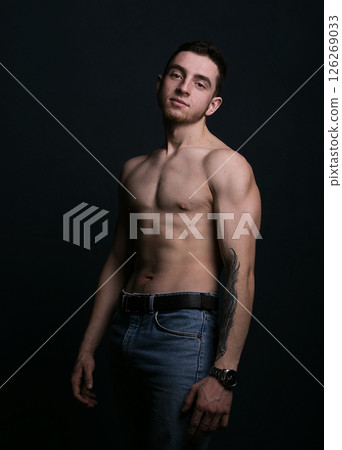 Muscular model sports young man on dark background. 126269033