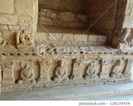 A Buddha statue on the base of the Buddha head at the ruins of the Molamoladu Buddhist monastery on the outskirts of Taxila, a strategic point east of Gandhara in Pakistan A Buddha statue on the base of the Buddha head at the ruins of the Molamoladu Buddhist monastery on the outskirts of Taxila, a strategic point east of Gandhara in Pakistan 126270434