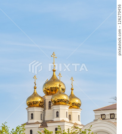 The golden domes of the Christian church in sunset light. 126270456