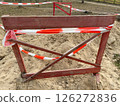 Wooden fence with red tape, sign that the passage is closed, construction work is underway 126272836