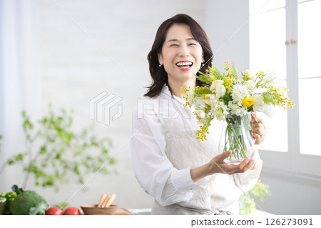 廚房裡拿著花瓶微笑的中年婦女 126273091