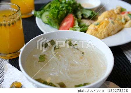 Vietnamese Chicken Soup warm bowl of Vietnamese chicken noodle soup with lime and fresh herbs being garnished 126273258