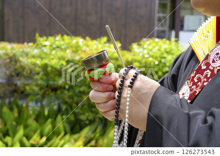 A monk ringing a chime at a cemetery A monk ringing a chime at a cemetery 126273543