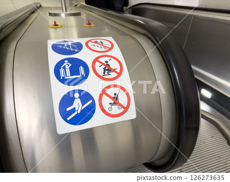 Escalator warning signs at metro or public transit station promote safety awareness and responsible passenger behavior in modern urban infrastructure environment 126273635