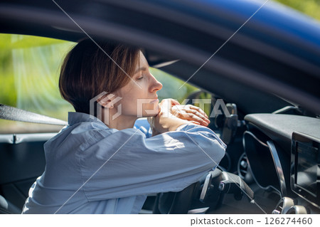 Pensive serious woman standing in traffic jam waiting driving car looking ahead. Pensive serious woman standing in traffic jam waiting driving car looking ahead. 126274460