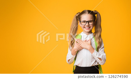 Thank You. Cute Schoolgirl Pressing Hands To Chest Expressing Gratitude To School Teachers Posing On Yellow Studio Background. Copy Space 126274590