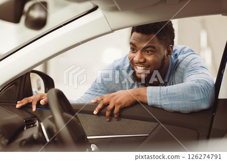 African American Man Buying Car Looking At Vehicle Interior Choosing New Auto In Dealership Center. Selective Focus 126274791