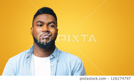 Portrait of african american man with sceptical face expression over yellow background with copy space 126274797