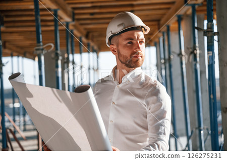 Reading the plan. Man is working on the construction site at daytime Reading the plan. Man is working on the construction site at daytime 126275231