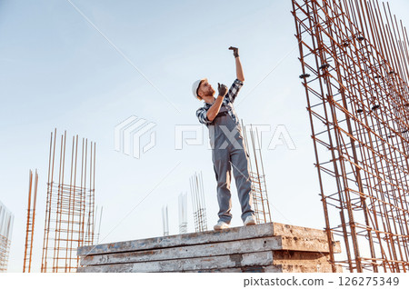 On construction site. Man in grey uniform is working On construction site. Man in grey uniform is working 126275349