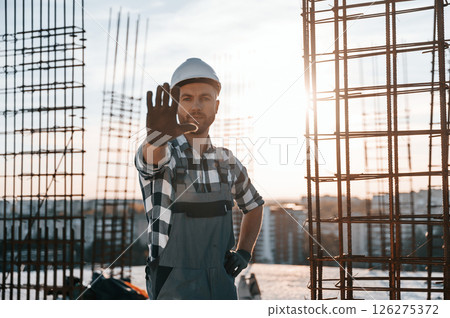 Restricted area. No trespassing. Man is working on the construction site at daytime Restricted area. No trespassing. Man is working on the construction site at daytime 126275372