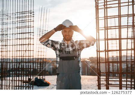 Standing in a beautiful sunlight. Man is working on the construction site at daytime Standing in a beautiful sunlight. Man is working on the construction site at daytime 126275377