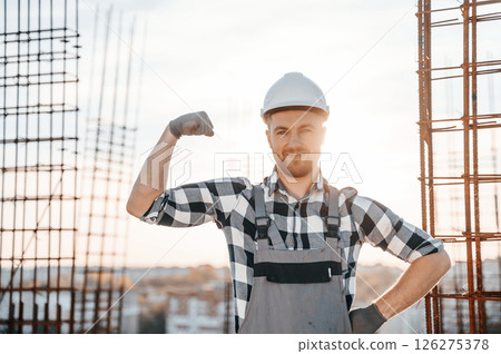 Showing biceps. Conception of succes. Man is working on the construction site at daytime 126275378