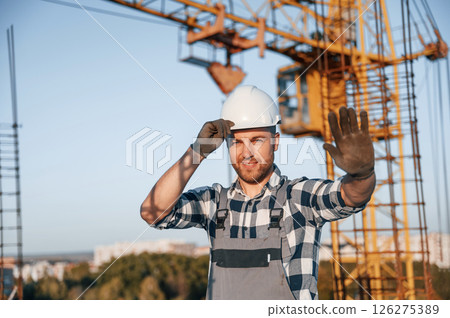 Stop gesture by the hand. Man is working on the construction site at daytime 126275389