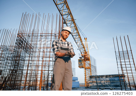 Wearing the gloves. Man is working on the construction site at daytime Wearing the gloves. Man is working on the construction site at daytime 126275403
