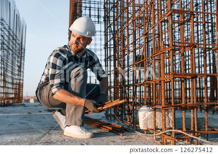 With rusty metal objects. Man is working on the construction site at daytime 126275412