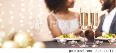 Two glasses of champagne over black couple in love, celebrating Valentine's Day at restaurant Two glasses of champagne over black couple in love, celebrating Valentine's Day at restaurant 126275813