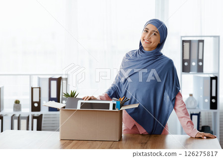 Promotion Concept. Smiling Muslim Female Office Employee Standing Near Desk With Box Full Of Her Belongings, Moving To New Workplace 126275817