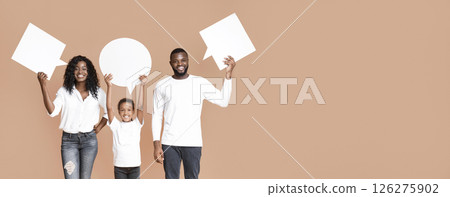 Diverse opinions. Empty speech bubbles in hands of happy black family of three over yellow background with free space. 126275902