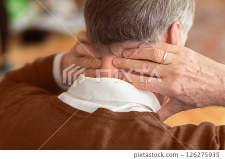 Unrecognizable Elderly Man Having Neck Pain Suffering From Arthritis Massaging Aching Nape Sitting On Sofa Indoor. Rear View, Selective Focus Unrecognizable Elderly Man Having Neck Pain Suffering From Arthritis Massaging Aching Nape Sitting On Sofa Indoor. Rear View, Selective Focus 126275935