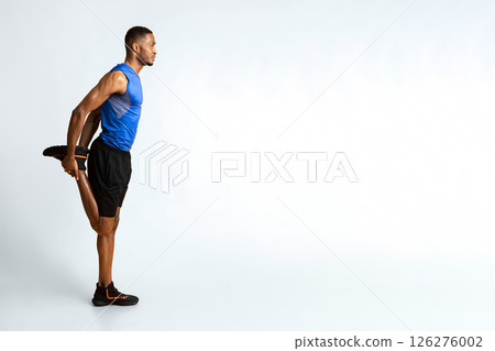 Warm Up. Side view of black man stretching legs before run over yellow studio wall, full length, copyspace Warm Up. Side view of black man stretching legs before run over yellow studio wall, full length, copyspace 126276002