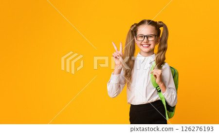 School Contest Winner. Smiling Schoolgirl Gesturing Victory Sign Over Yellow Background In Studio. Copy Space 126276193