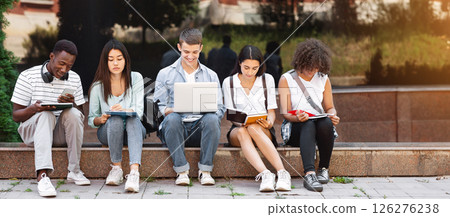 Preparing For Lectures. Group Of Multi-Ethnic Students Studying Together Outdoors, Using Laptop And Taking Notes To Workbooks, Panorama 126276238