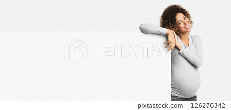 Great offer. Happy afro pregnant woman near blank poster over white background, panorama with empty space Great offer. Happy afro pregnant woman near blank poster over white background, panorama with empty space 126276342