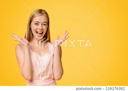 Happily Surprised. Portrait Of Joyful Teen Girl Raising Hands With Excitement, Posing Over Yellow Background, Free Space Happily Surprised. Portrait Of Joyful Teen Girl Raising Hands With Excitement, Posing Over Yellow Background, Free Space 126276362