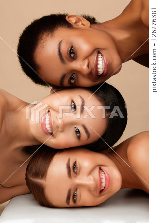 Three Diverse Girls With Perfect Faces And Skin Posing Together Smiling To Camera On Gray Background. Multicultural Beauty Concept. Vertical Three Diverse Girls With Perfect Faces And Skin Posing Together Smiling To Camera On Gray Background. Multicultural Beauty Concept. Vertical 126276381