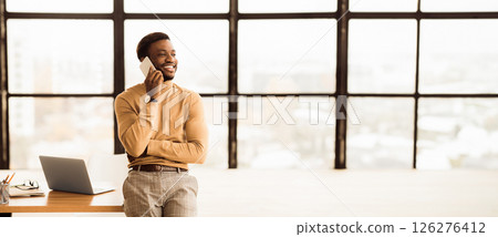 Business Concept. African executive talking on smart phone solving business problems remotely. Empty space 126276412