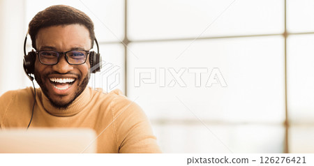 Tech Support. Portrait of handsome black sales manager with headset working in call center. Empty space Tech Support. Portrait of handsome black sales manager with headset working in call center. Empty space 126276421