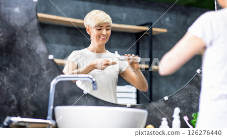 Skincare Routine. Happy Lady Applying Micellar Water On Cotton Pad Cleansing Skin In Bathroom At Home. Selective Focus Skincare Routine. Happy Lady Applying Micellar Water On Cotton Pad Cleansing Skin In Bathroom At Home. Selective Focus 126276440