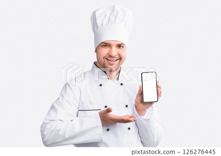 Restaurant Chef Showing Cellphone With Empty Screen Recommending Food Delivery Service Standing On White Studio Background. Panorama 126276445
