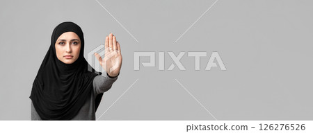 No abuse and discrimination. Muslim woman in hijab making stop gesture with her hand, covering her face with open palm over gray background No abuse and discrimination. Muslim woman in hijab making stop gesture with her hand, covering her face with open palm over gray background 126276526