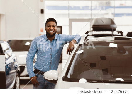 Car Buyer. Happy Afro Man Standing Posing Near New Auto In Dealership Store. Copy Space Car Buyer. Happy Afro Man Standing Posing Near New Auto In Dealership Store. Copy Space 126276574