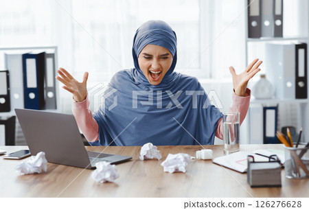 Deadline Stress Concept. Angry Arabic Woman Office Employee Having Nervous Breakdown At Workplace, Shouting And Emotionally Gesturing Deadline Stress Concept. Angry Arabic Woman Office Employee Having Nervous Breakdown At Workplace, Shouting And Emotionally Gesturing 126276628
