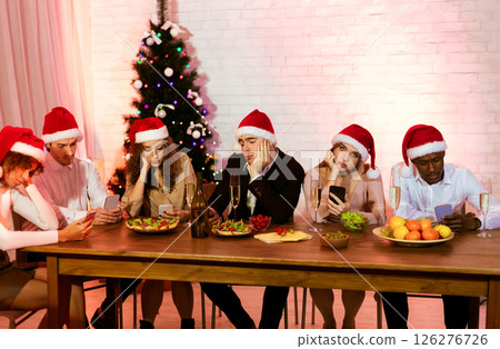 Boring Party. Bored Diverse Friends Using Phones Sitting At Table Celebrating Christmas Or New Year At Home 126276726
