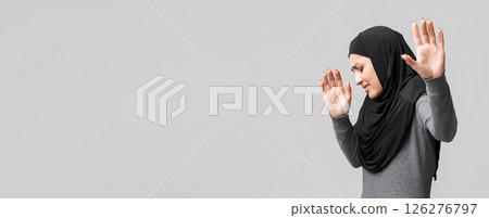 Domestic Violence Among Muslim Women. Afraid islamic girl gesturing stop with open palms, trying to protect herself from abuse, grey background 126276797