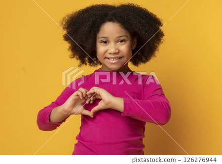 Love Concept. Adorable Little African American Girl Showing Heart Gesture With Hands Over Yellow Background In Studio, Free Space Love Concept. Adorable Little African American Girl Showing Heart Gesture With Hands Over Yellow Background In Studio, Free Space 126276944