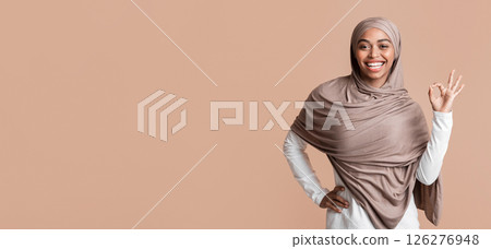 Everything is fine. Cheerful afro muslim girl in headscarf showing ok sign over yellow studio background, empty space 126276948