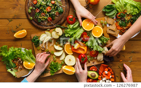 Healthy food dinner table. Women at home together, eating fruits and vegetables, top view, flat lay, crop Healthy food dinner table. Women at home together, eating fruits and vegetables, top view, flat lay, crop 126276987