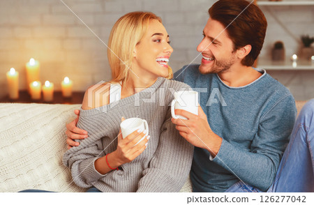 Date At Home. Loving Couple Laughing Drinking Coffee And Talking Hugging Sitting On Sofa Indoor In The Evening. Selective Focus 126277042