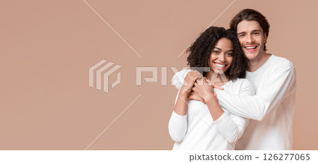 International love. Romantic multiracial couple embracing, posing together over yellow background in studio, copy space 126277065