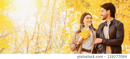 Romantic smiling couple walking through autumn park, talking and enjoying date, panorama with free space 126277084