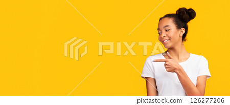 Advertisement Concept. Attractive afro girl presenting with hand and pointing with finger. Panorama, free space Advertisement Concept. Attractive afro girl presenting with hand and pointing with finger. Panorama, free space 126277206