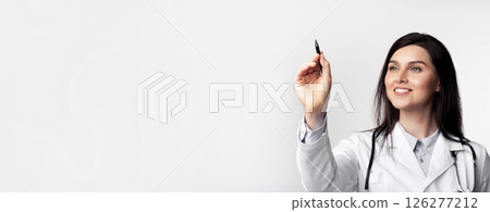 Female Doctor Holding Stylus Drawing On Invisible Medical Screen Standing Over White Studio Background. Copy Space Female Doctor Holding Stylus Drawing On Invisible Medical Screen Standing Over White Studio Background. Copy Space 126277212