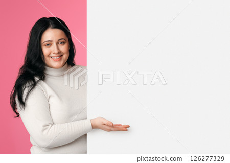 Place For Your Ad. Beautiful Plus Size Girl Holding And Pointing At Blank White Advertisement Board With Open Palm, Panorama 126277329