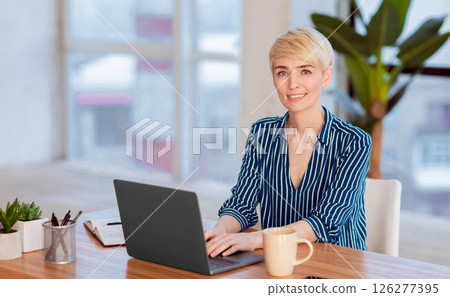 Computer Work. Entrepreneur Woman Working On Laptop Browsing Internet Smiling To Camera Sitting At Workplace Indoor. Free Space 126277395