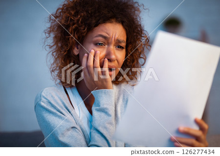 Disappointed woman reading letter of break up from boyfriend, girl covering mouth with hand Disappointed woman reading letter of break up from boyfriend, girl covering mouth with hand 126277434